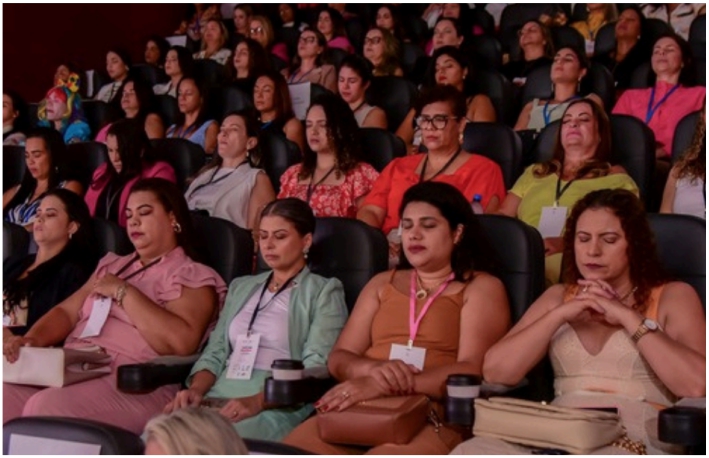DJ facing a crowd at his deck. Photo with a purple hue